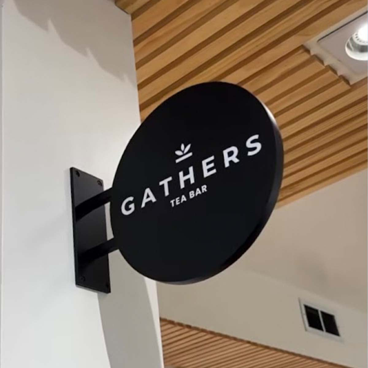 Rond zwart aluminium uithangbord met logo, voorbeeld